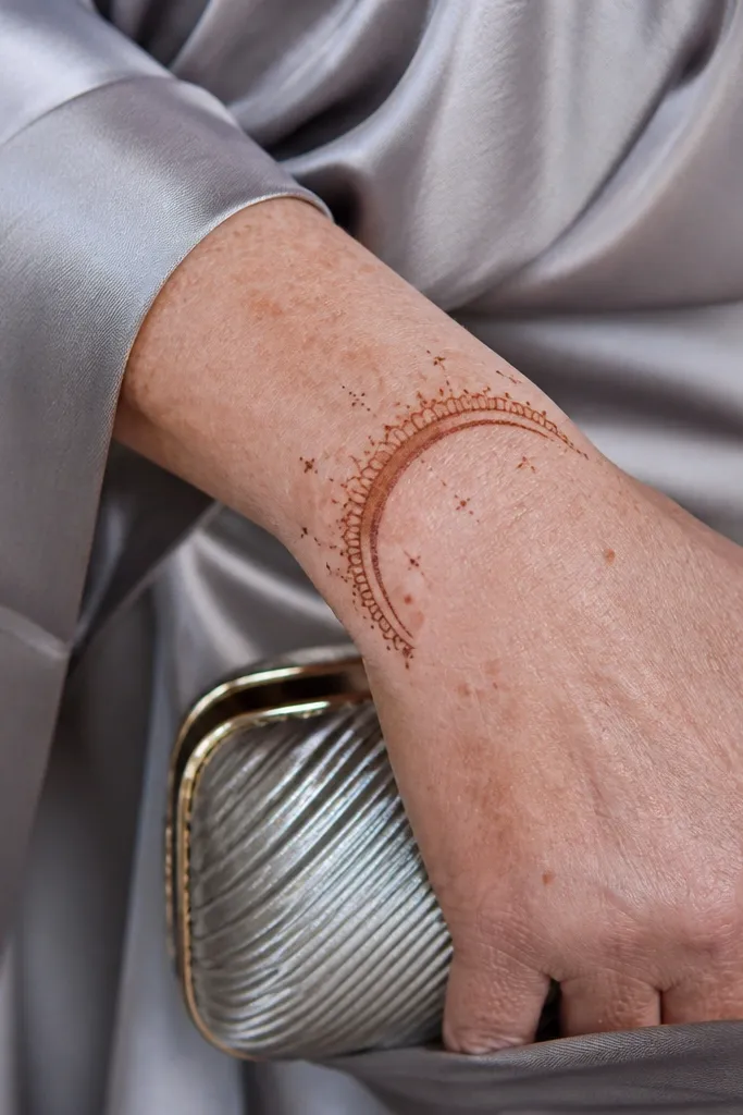 A half-moon frame at the wrist with tiny star-like dots