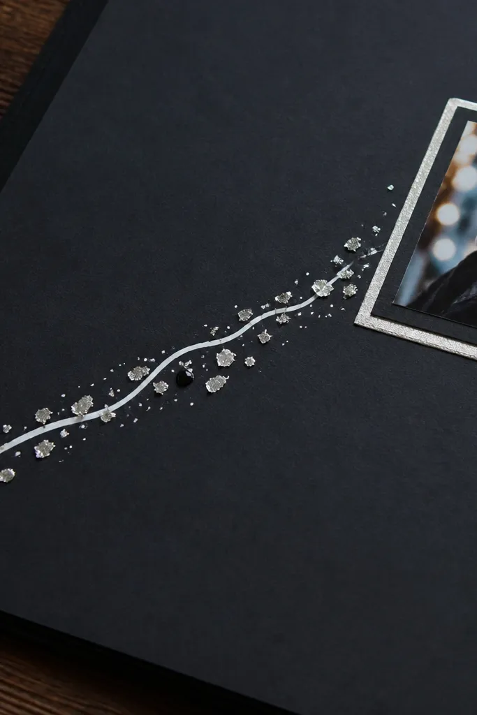 A black scrapbook page with white gel pen text and a small