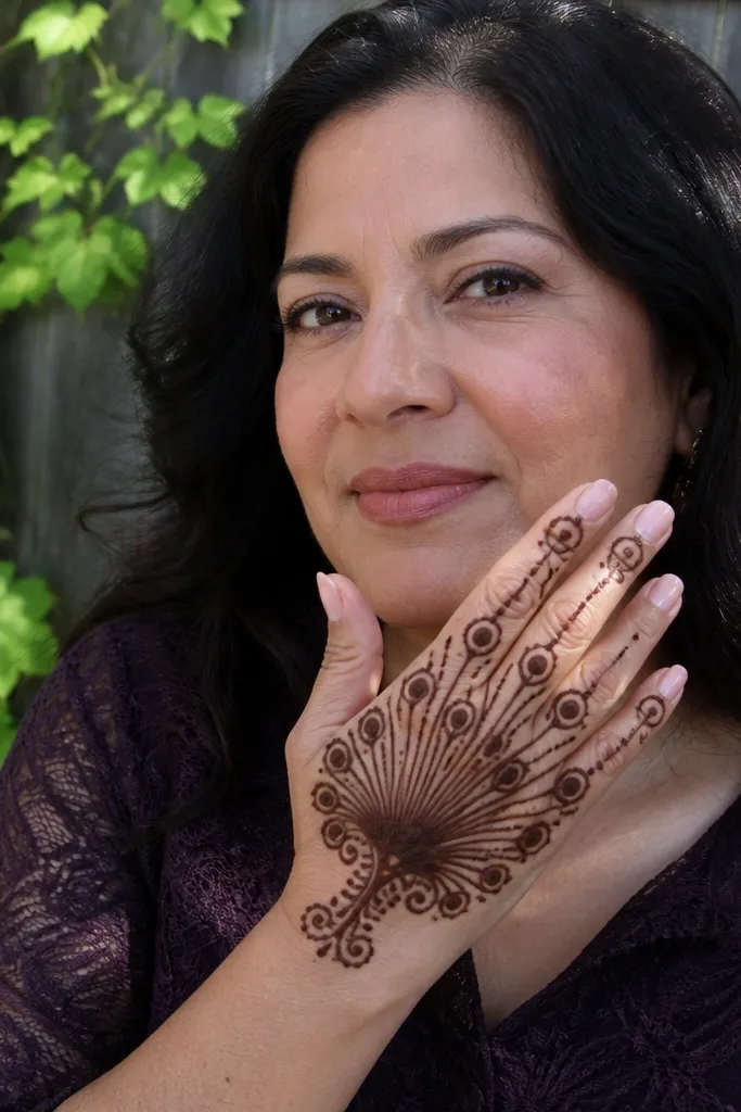 Peacock-feather fan shape on back of hand with small eye motifs