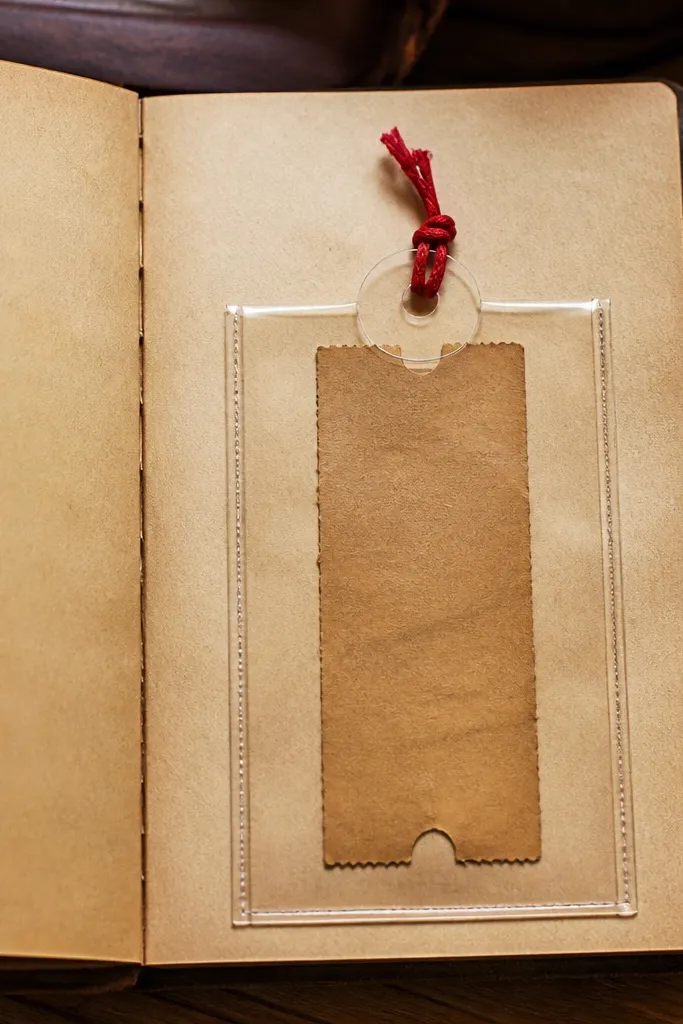 A tea-stained pocket page with a ticket strip and a red thread tie closure
