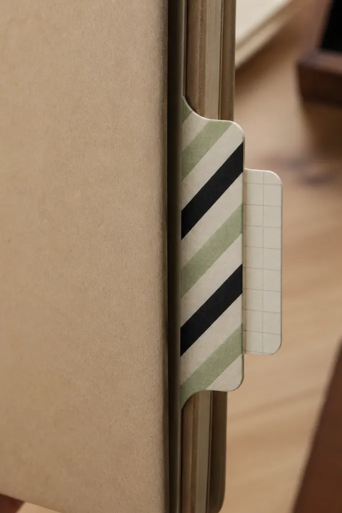A page with a washi-wrapped tab and small numbered inserts tucked inside