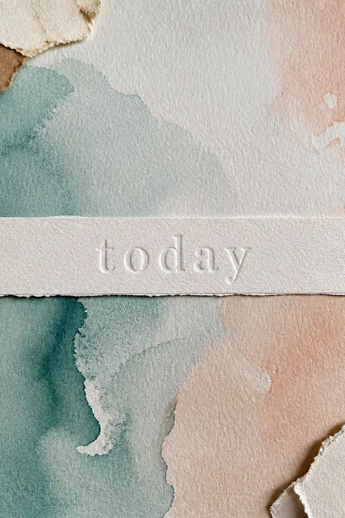 A soft watercolor wash page with a raised word strip and small scraps
