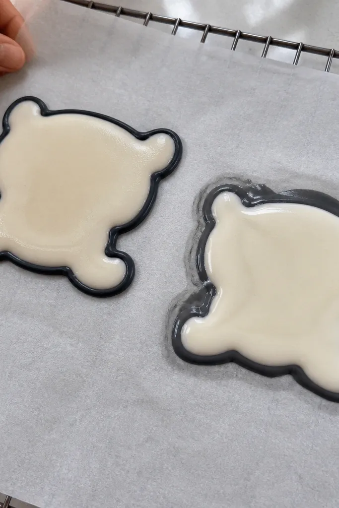 Thin icing outline with a separate thicker icing fill inside a cake drawing shape