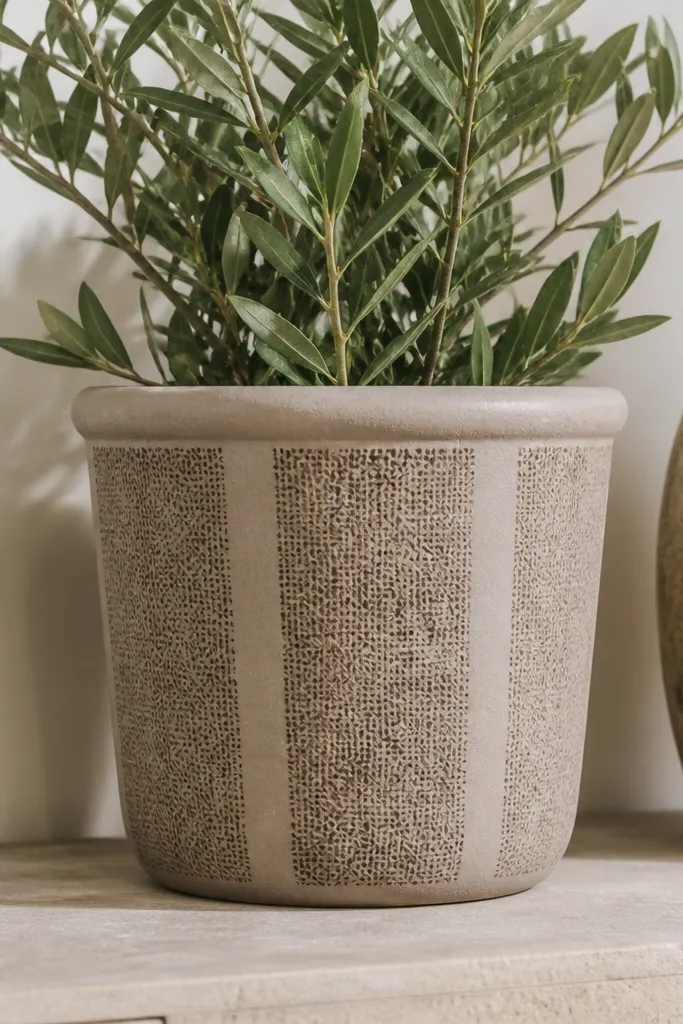 A taupe pot with three vertical panels that look like burlap texture made from sponge dabbing; darker lines run through the panels.