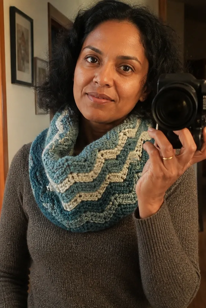 A ribbed ripple crochet cowl in muted blue with gentle waves