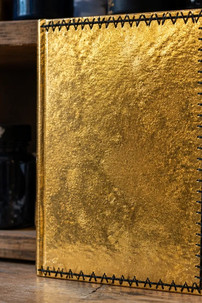 Gold leaf effect paper journal cover with a black stitched border frame