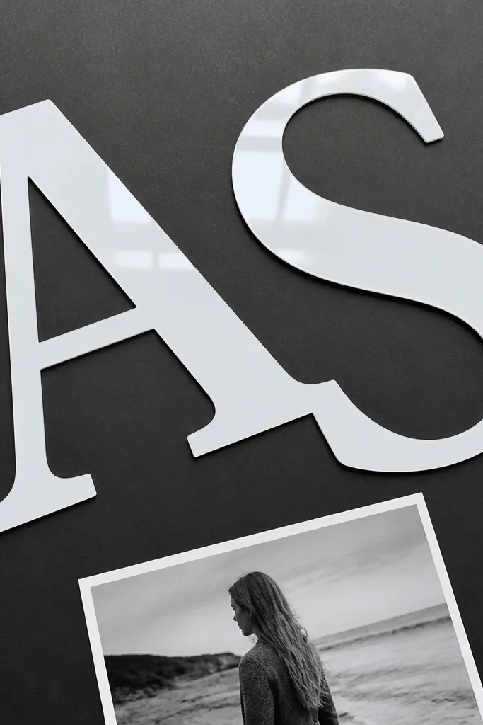 A matte scrapbook page with glossy cutout letters and a small cluster