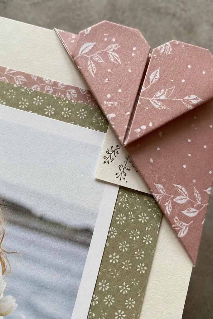 A scrapbook page with an origami heart corner holding a hidden message strip