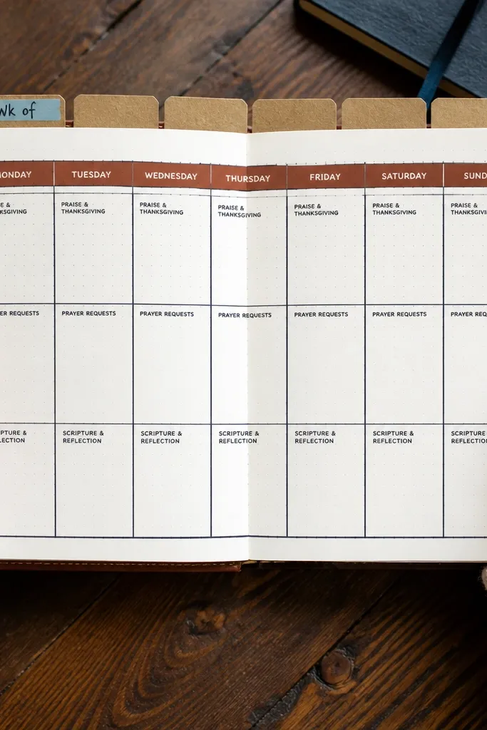 Notebook page with a neat grid, date tabs, and black-gray lines with a terracotta accent.