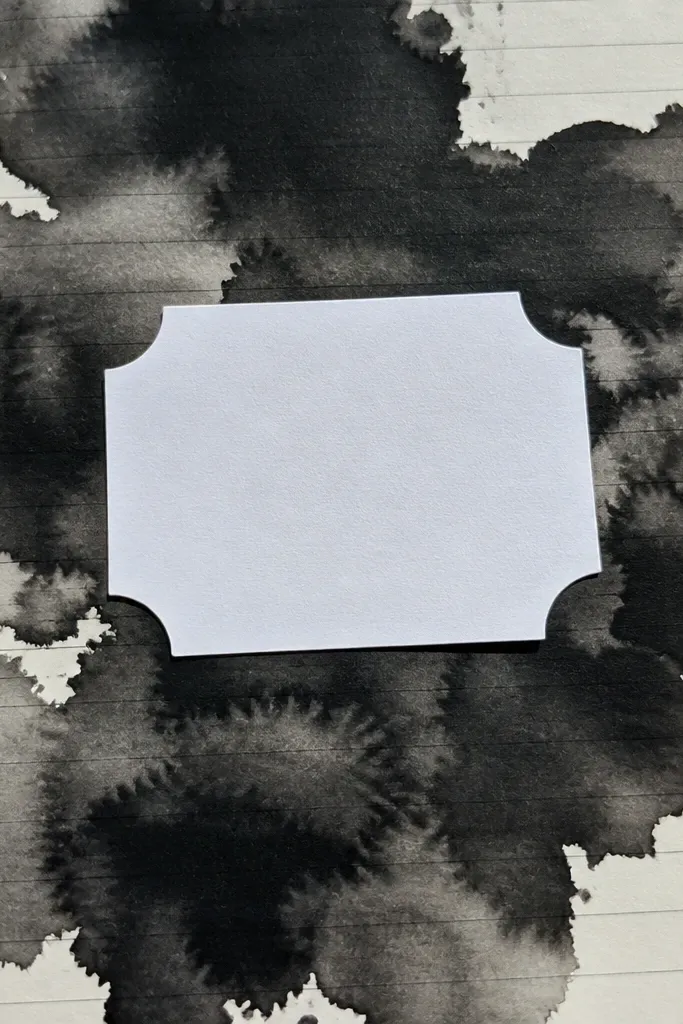 A dark ink blot background with a crisp white label on top