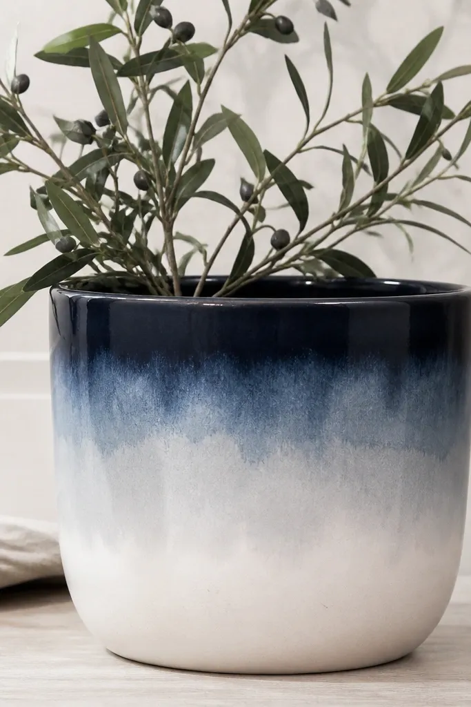 A pot with a deep navy rim and a soft watercolor ombre wash fading from navy to pale gray-white toward the bottom; the paint looks feathered at the edges.