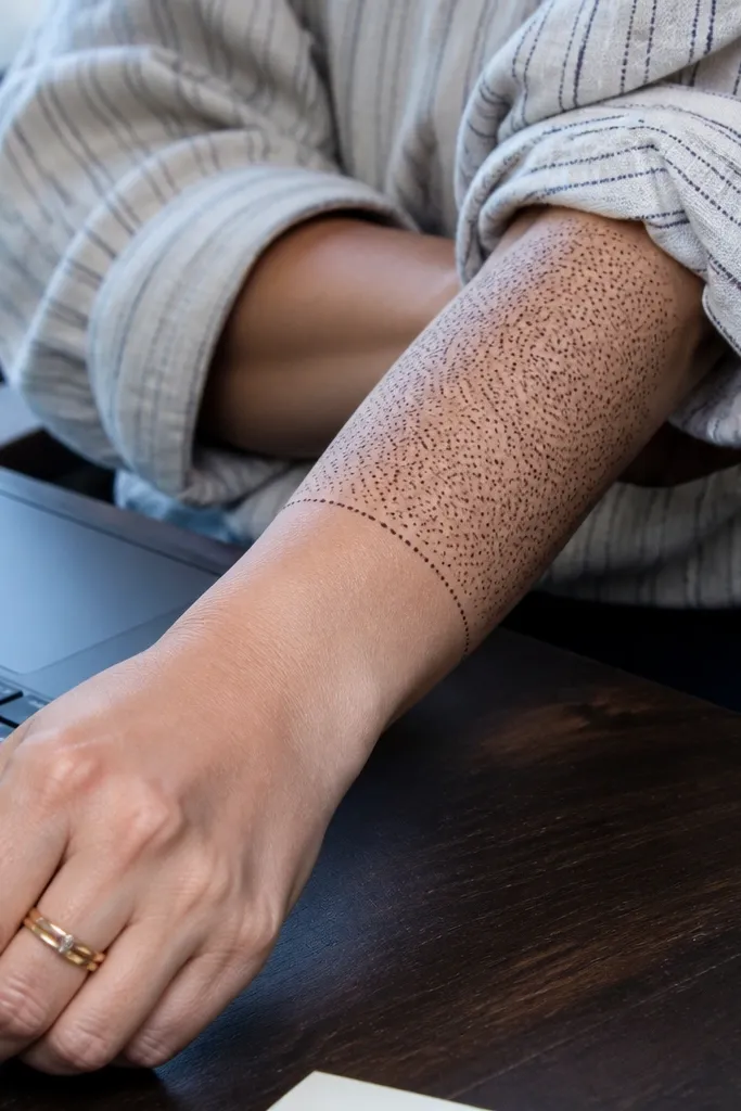 Small micro-dot pattern on the lower forearm with a clean wrist stop line