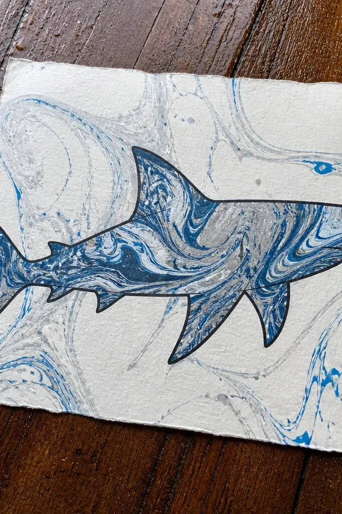 Shark outline filled with swirling marbled blue and teal water pattern