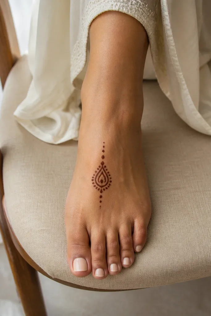 A single teardrop motif on the top center with tiny surrounding dots