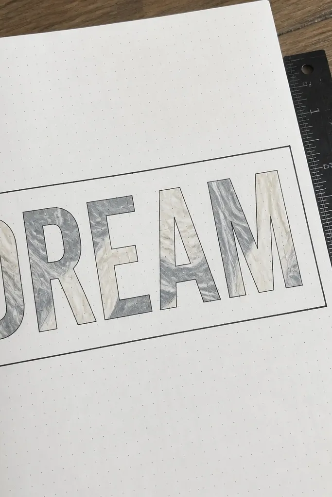 A thin banner across the page with marbled letters and a black outline border