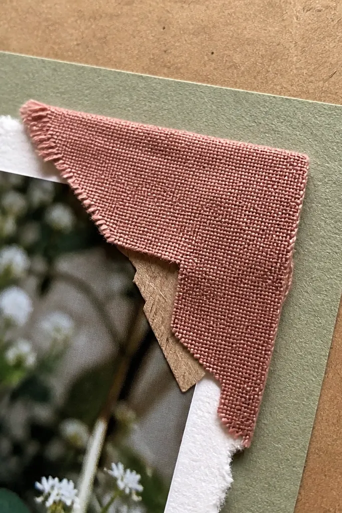 Small fabric squares glued in corners holding a mat on a scrapbook page