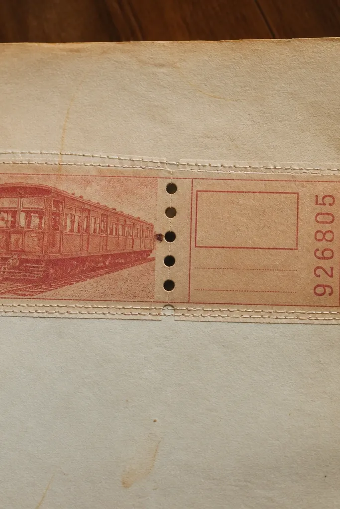 A strip of ticket stubs stitched with two rows of thread along the page